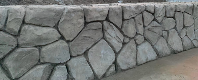 A stone wall with a bench in front of it